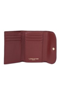 Portafoglio in pelle bordeaux con superficie texturizzata, molteplici scomparti per carte e hardware in tonalità oro con logo impresso. Design compatto e pieghevole.