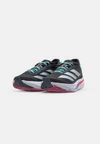 Zwarte hardloopschoenen met teal veters, voorzien van drie witte strepen aan de zijkant, een gewatteerde bovenkant en een zool met roze accenten.