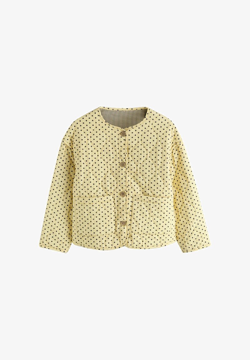 Rumena prešita jakna s črnimi pikami, okrogel ovratnik, sprednji gumbi, dva sprednja žepa in dolgi rokavi.