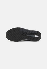 Black athletic shoe sole with a textured pattern, featuring a central white stripe and "DUAL DENSITY" embossed detail.