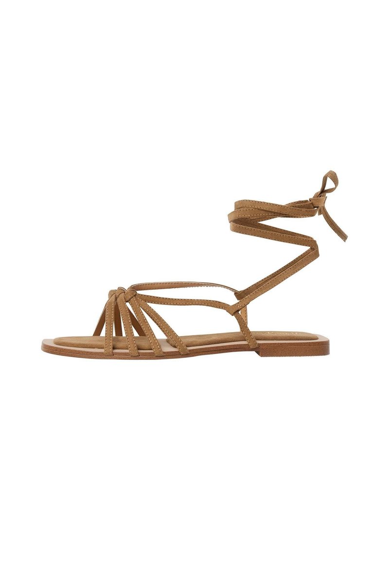 Bruna sandaler med flera smala remmar, flat sula och vristsnörning. Tillverkade i mjukt material med mockaliknande textur.