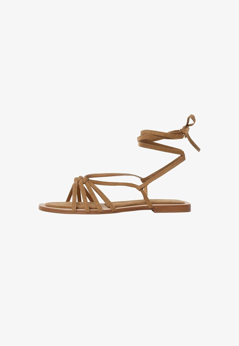 Bruna sandaler med flera smala remmar, flat sula och vristsnörning. Tillverkade i mjukt material med mockaliknande textur.