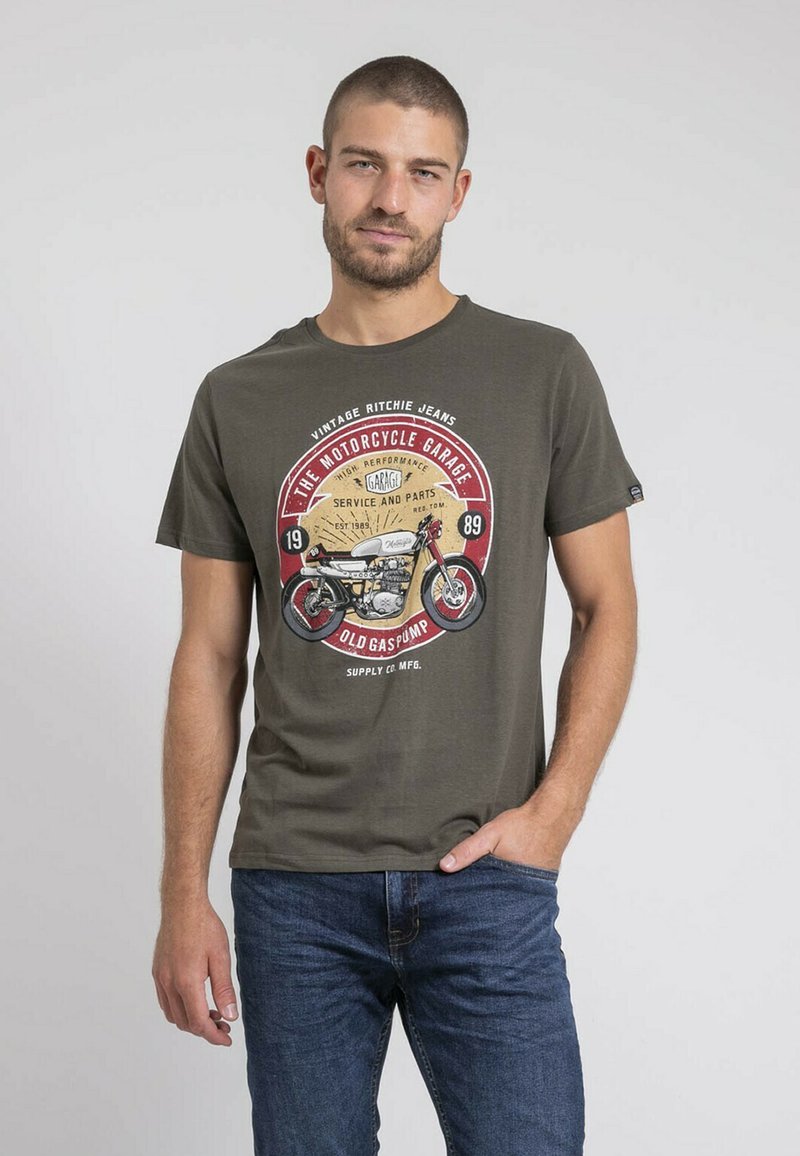 T-shirt en coton vert olive avec un motif de moto vintage en rouge et beige, manches courtes et encolure ronde.