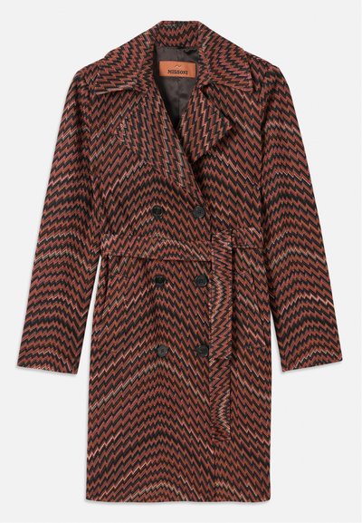 Divvirsies mētelis ar zigzag rakstu rūsu, melnā un zelta krāsā. Izgatavots no teksturēta auduma ar izgrieztiem atloci un jostu.