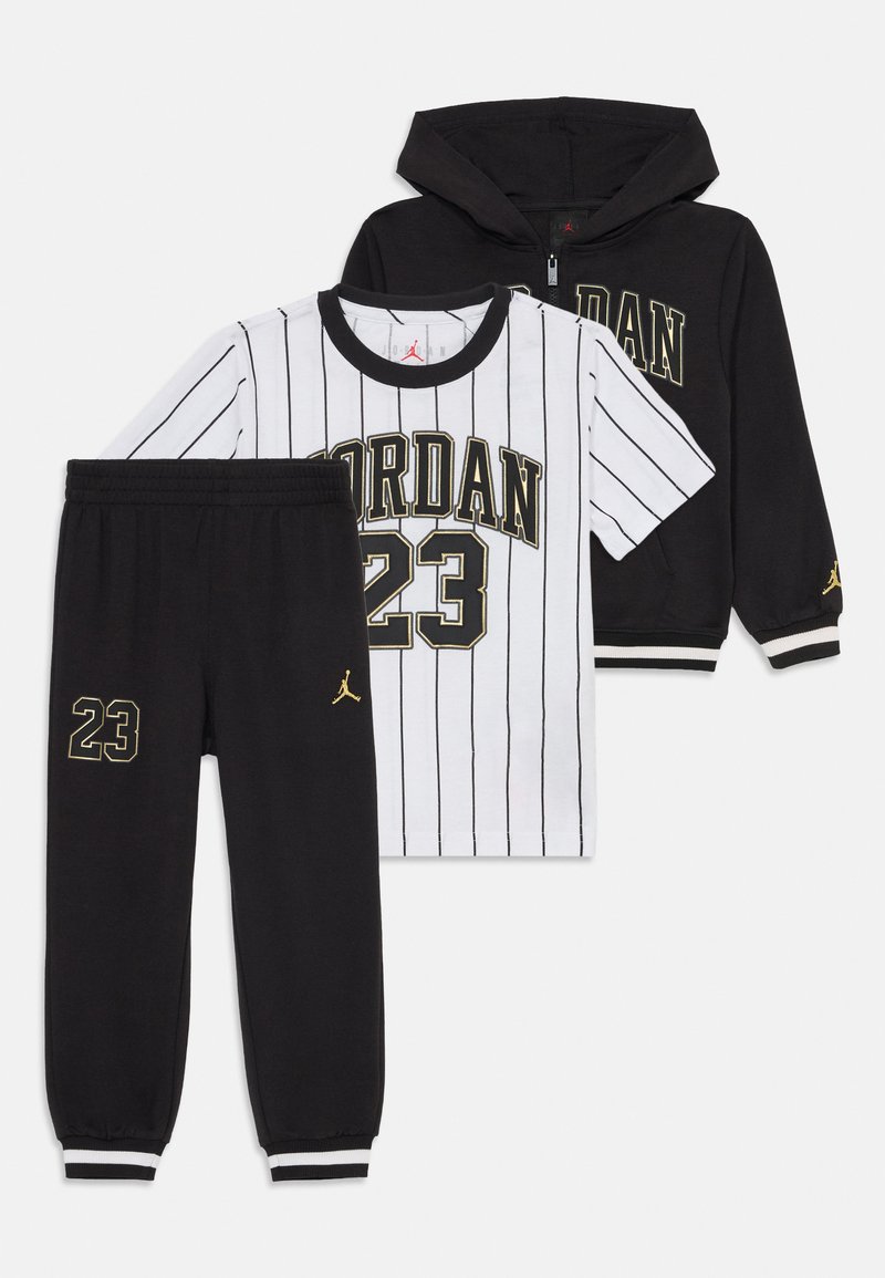 Crna zip-up dukserica i hlače s natpisom "23" i zlatnim Jumpman logotipima, upareni s bijelom majicom s kratkim rukavima i prugama "Jordan 23".