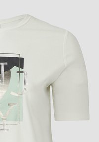 Nahaufnahme eines weißen Kurzarm-T-Shirts mit geometrischem Grafikdesign in Schwarz, Hellblau und metallischem Silber auf der Brust.