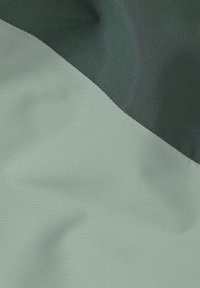 Strukturiertes Gewebe mit einem hellgrünen Abschnitt und einem dunkelgrünen oberen Abschnitt, mit glatter, matter Oberfläche und sauberen, geschnittenen Kanten.