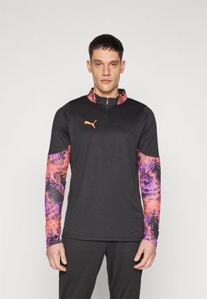 Maglietta sportiva a maniche lunghe nera, con logo Puma arancione. Le maniche presentano un vivace motivo astratto viola e arancione. Collo alto con zip.