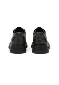 Chaussures en cuir noir avec une texture craquelée, dos rond et semelle en caoutchouc noir. Présente un logo discret près du talon.