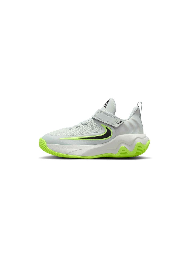 Zapatilla deportiva blanca con parte superior texturizada, correa ajustable y suela de color verde brillante. Presenta acentos en negro y verde en el costado.