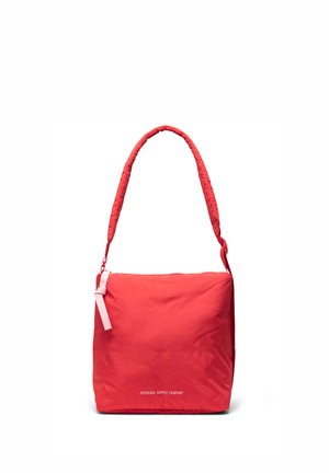 Sac d'épaule rouge en forme carrée avec sangle rembourrée et fermeture éclair, avec le texte "Herschel Supply Company" sur le devant.