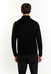 Schwarzer, gestrickter Pullover mit hohem Kragen und gerippten Bündchen, mit nahtlosem Rücken und taillierter Passform.