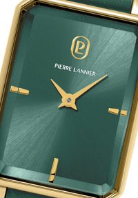 Green watch face with gold accents, featuring rectangular, brushed texture, and sharp angles. Brand name "Pierre Lannier" displayed.