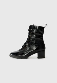 Botas tobilleras de charol negro con cierre de cordones en la parte delantera, ojales dorados y un tacón cuadrado. Patrón texturizado en la superficie, tira de sujeción reforzada.