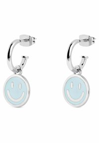 Orecchini a cerchio argentati con un charm in smalto a forma di faccina sorridente blu chiaro. Il design include una forma circolare con accenti bianchi ai bordi.