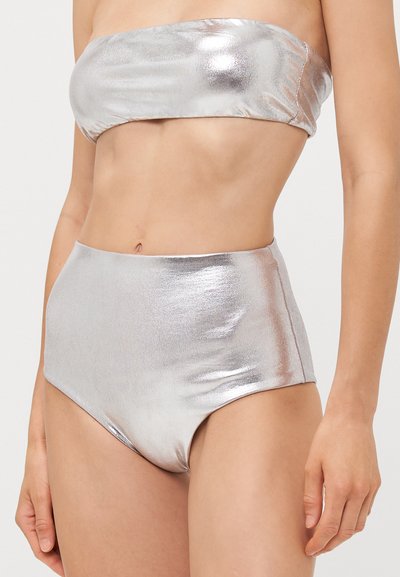 Costum de baie metalic argintiu format din două piese, cu un top fără bretele și un fund înalt, având o textură netedă și lucioasă, cu un design fără cusături.