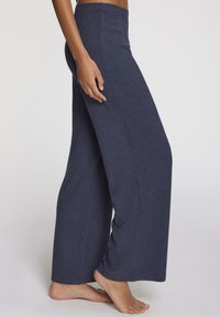 Mornarsko široke hlače iz rebraste tkanine. Visok pas s gladko teksturo in sproščenim prileganjem, prikazane s stranskega kota.