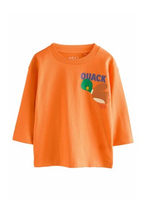 Orange T-Shirt aus Baumwolle mit kurzen Ärmeln, das ein buntes Entenmotiv und den auffälligen Text "QUACK" auf der Vorderseite aufgedruckt hat.