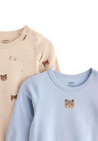 Zwei langärmlige Baumwolloberteile: eines beige mit Bärenmotiv, das andere hellblau mit Bärenmotiv, beide mit runden Ausschnitten und Druckknöpfen.