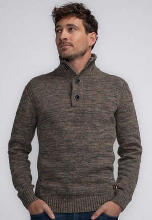 Brauner Strickpullover mit hohem Kragen, ausgestattet mit zwei großen Knöpfen sowie gerippten Bündchen und Saum. Texturiertes Muster im gesamten Stoff.
