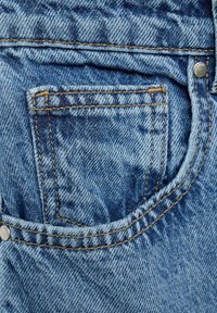 Jeans din denim, având un buzunar posterior cu cusături portocalii contrastante și un țepuș metalic, prezentând o textură clasică de spălare albastră.