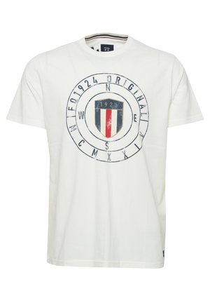 Bijela pamučna majica s okruglim grafičkim uzorkom u središtu koja prikazuje štit s plavim, crvenim i bijelim prugama, uz natpis u mornarskoj plavoj boji.