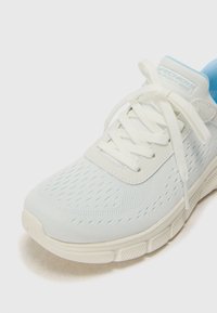 Pantof sportiv de culoare albastru deschis, din material mesh, cu vârf rotund, șireturi albe și o talpă căptușită cu detalii texturate.