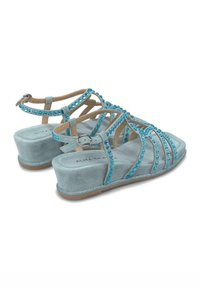 Sandali con zeppa in suede celeste chiaro, dotati di molteplici cinghie incrociate adornate con strass turchesi e una suola luccicante.