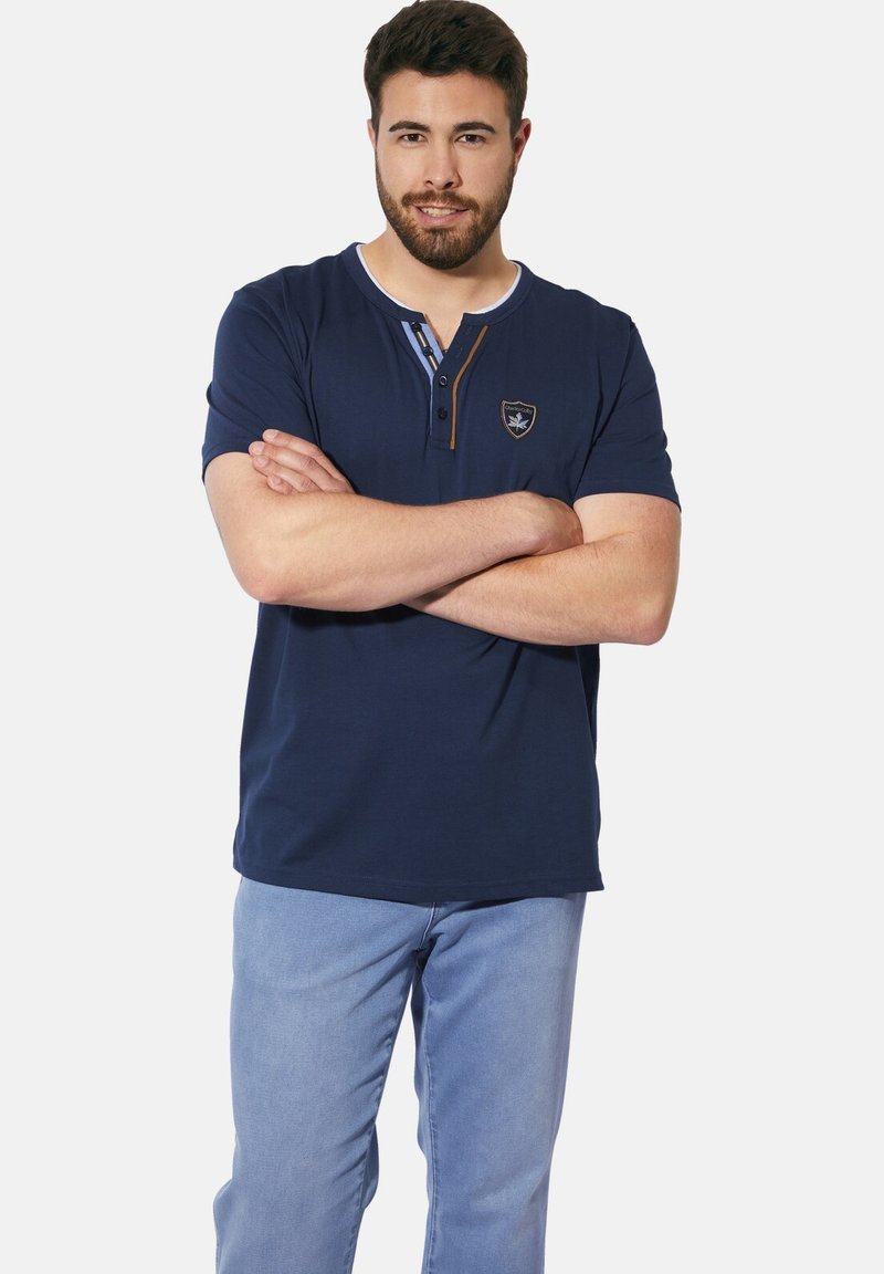 Navy blue short-sleeve polo shirt with a buttoned placket, contrast stitching, and a small embroidered logo on the chest.