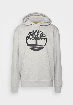 Grå hoodie med en stor svart trädlogotyp på framsidan, med dragsko-integrerad huva, ribbade ärmslut och en kenguruficka.