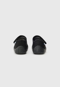 Scarpe in tessuto nero con taglio basso e retro arrotondato, caratterizzate da una suola in gomma nera texturizzata e un piccolo accento blu sul lato.