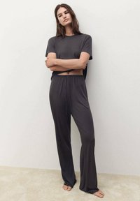 Šedý dvoudílný outfit skládající se z volného trička a kalhot s elastickým pasem. Měkká, hladká tkanina s uvolněným střihem.