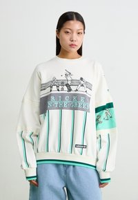 Λευκή φούτερ μπλούζα με τιρκουάζ ρίγες, γραφική εκτύπωση αθλητών του κρίκετ και κείμενο "RICKEN N-THE-GREEN". Λογότυπο Adidas κοντά στο στρίφωμα.