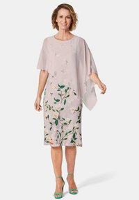Floral Kleid mit einem hellrosa durchsichtigen Überzug, der mit einem botanischen Druck in Grün und Gelb verziert ist. Offene Ärmeln erzeugen einen gestuften Effekt.