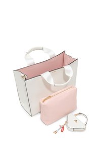 Tote taske i hvid læder med en pink indvendig, der indeholder to mindre punge: en pink lynlåspung med geometrisk mønster og en trekantet nøglekæde.