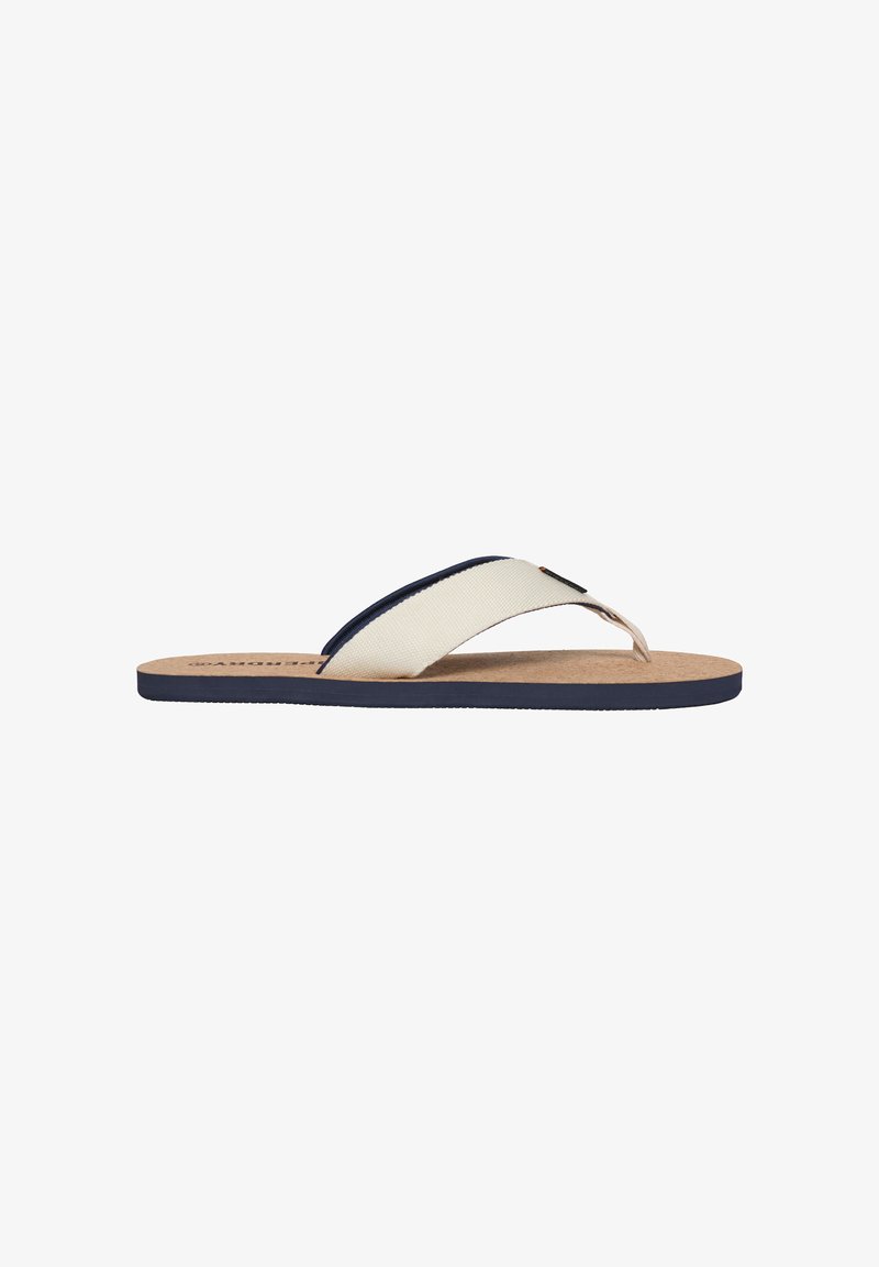 Chancla de color beige claro con acentos en navy, tiras de tela y una plantilla de corcho. Cuenta con una suela de goma texturizada para un mejor agarre y durabilidad.