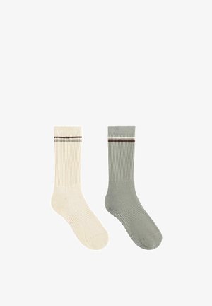 Par nogavic do posadke z rebrastim vzorcem, ena kremne in ena sive barve, vsaka z eno samo vodoravno rjavo-belo črto blizu vrha.