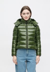 Grøn dunjakke med lynlås foran, høj krave og aftagelig hætte. Har quiltet tekstur og en let cropped pasform.