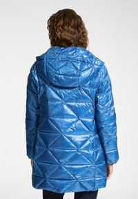 Lichtblauwe pufferjas met capuchon, voorzien van een ruitpatroon, glanzende textuur en lange mouwen. De achterkant toont de verlengde lengte.