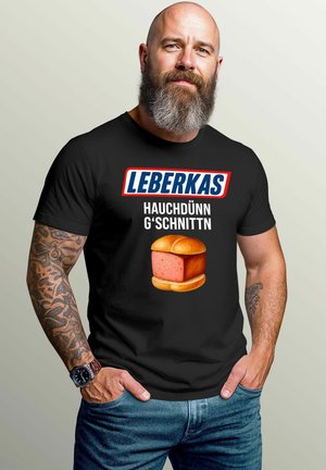 Schwarzes T-Shirt mit auffälligem weißen und roten Text "LEBERKAS HAUCHDÜNN G'SCHNITTN" über einer Grafik einer rosa Fleischscheibe in einem Brötchen.