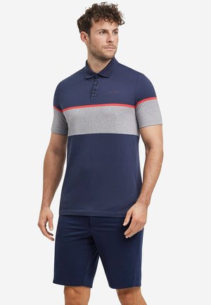 Navyblauw poloshirt met grijze horizontale strepen, rode accenten, drie-knopen sluiting, korte mouwen, gecombineerd met navy shorts.