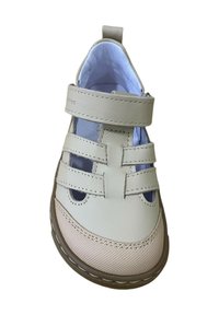 Zapato de cuero beige claro con tres correas de Velcro, textura suave, forma redondeada y suela de goma color miel. El interior es de un suave tono azul.