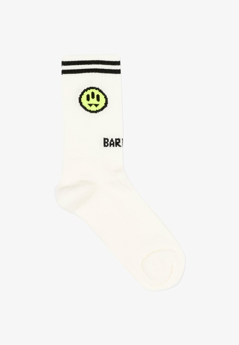 Chaussette blanche avec deux rayures noires en haut, un visage souriant néon vert avec des crocs, et un texte noir partiel "BAR" visible.