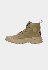 Καφέ ψηλά παπούτσια κατασκευασμένα από ανθεκτικό ύφασμα με στρογγυλό λογότυπο, μαύρες λεπτομέρειες και υφασμένο πέλμα για καλύτερη πρόσφυση. Διαθέτουν κορδόνια και θηλιά έλξης.