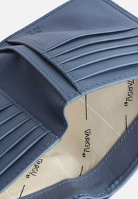 Wallet made of navy leather with stitched pleats, featuring a light-colored interior and brand logo. Closed, showing interior pattern lines.