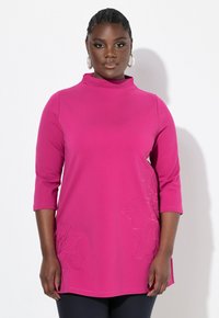 Maglione fucsia a collo alto con maniche a tre quarti. Presenta una leggera ricamo floreale sul lato e una vestibilità comoda.