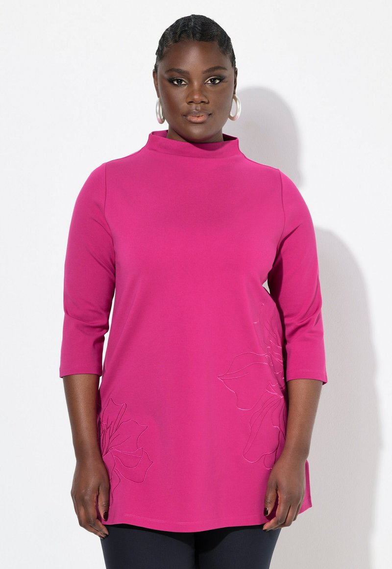 Maglione fucsia a collo alto con maniche a tre quarti. Presenta una leggera ricamo floreale sul lato e una vestibilità comoda.
