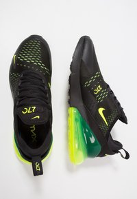 Svarta Nike Air Max 270-sneakers med neongröna detaljer, ovandel i mesh, vadderad krage och en distinkt stor luftdämpningsenhet vid hälen.