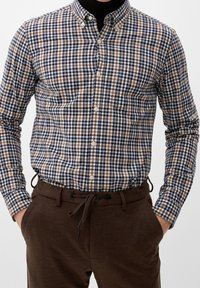 Hemd met knopen voor heren, voorzien van een marineblauw, wit en bruin geruit patroon. Glad materiaal, met een button-down kraag, gecombineerd met bruin trekkoordbroeken.