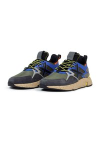 Zapatillas deportivas con un upper de malla verde, acentos de ante negro, superposiciones en azul y gris, cordones de un amarillo neón y una suela beige moteada.